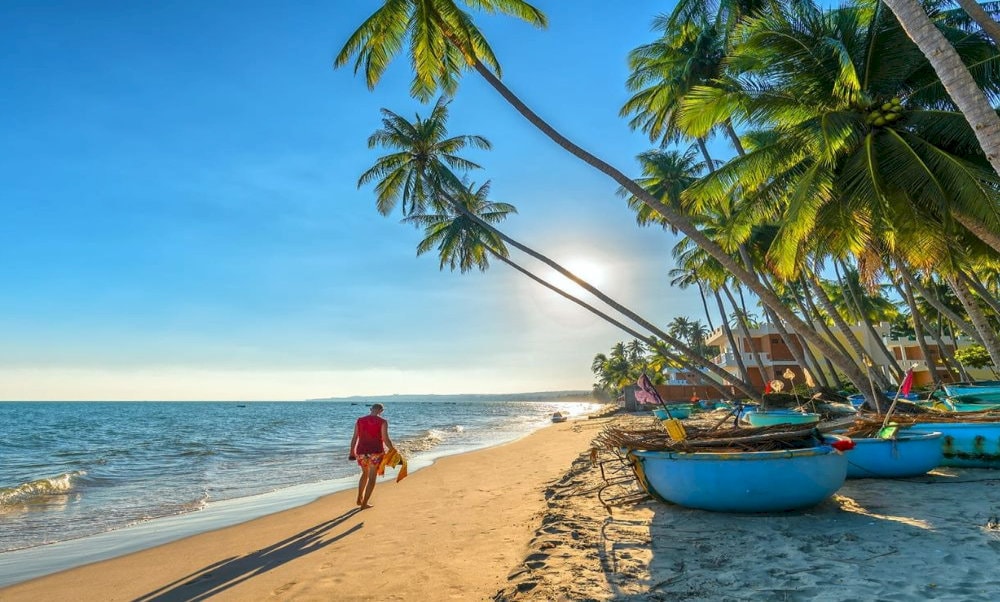 Bãi biển Mũi Né với những chiếc thuyền thúng và hàng dừa xanh mát