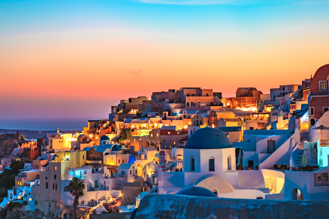 Cảnh hoàng hôn tuyệt đẹp ở Santorini với những ngôi nhà trắng và biển xanh.