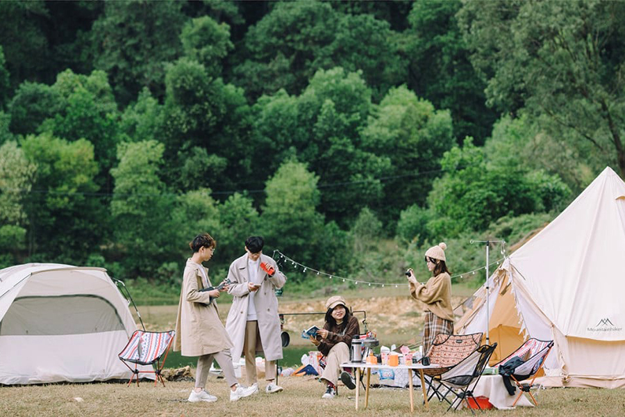 Một chiếc lều nhỏ nằm yên bình bên bờ hồ, giữa khung cảnh núi non hùng vĩ.