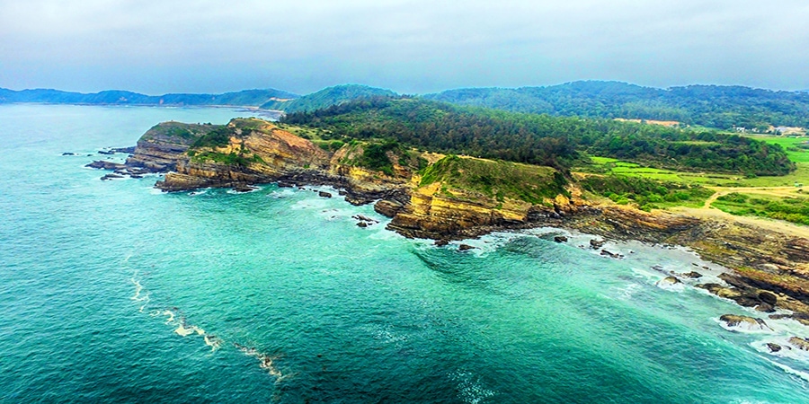 Bãi biển cát trắng yên bình với những hàng cây xanh và núi đá vôi ở Vịnh Lan Hạ