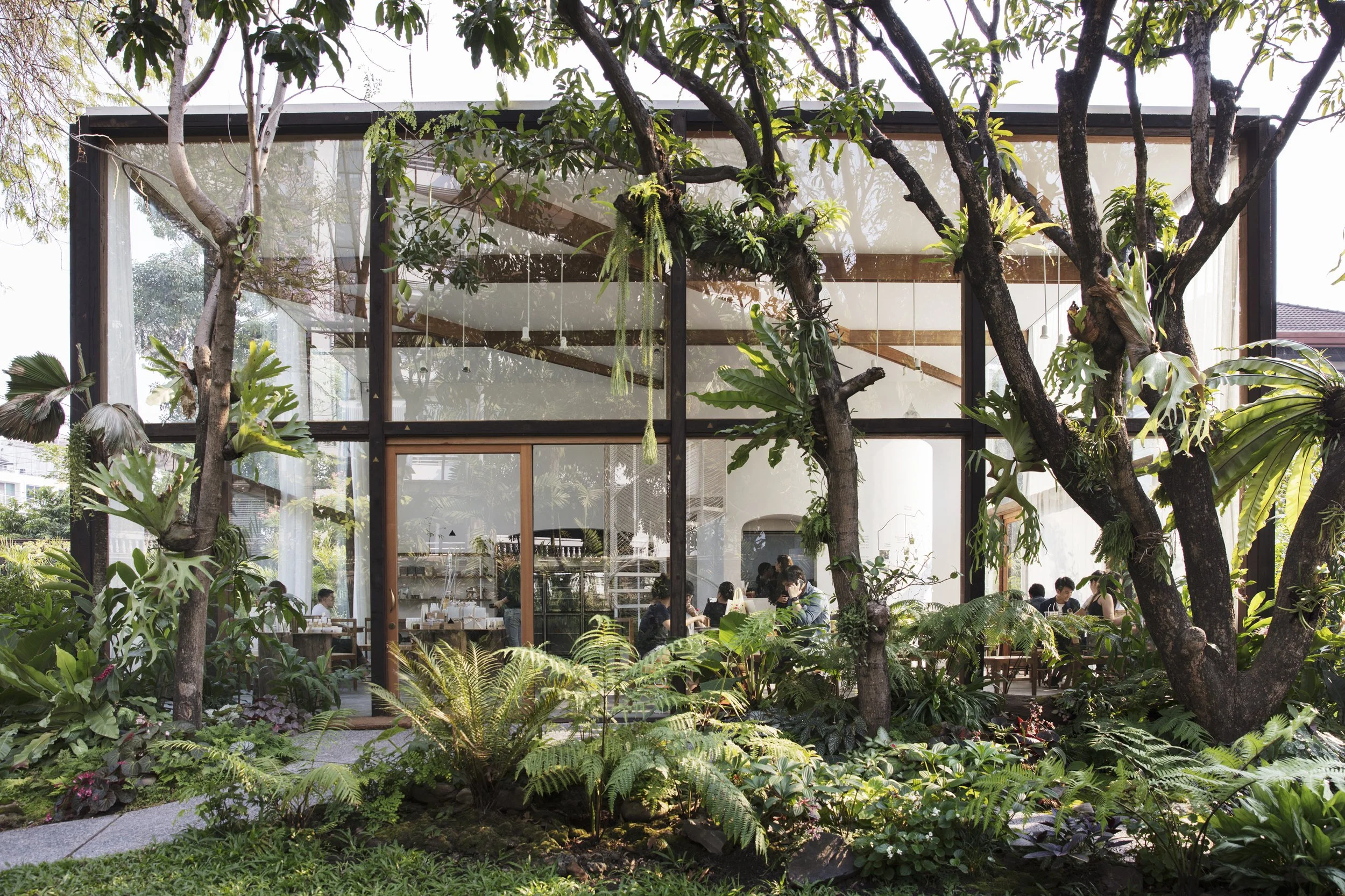 Patom Organic Living exterior with lush green garden and glasshouse