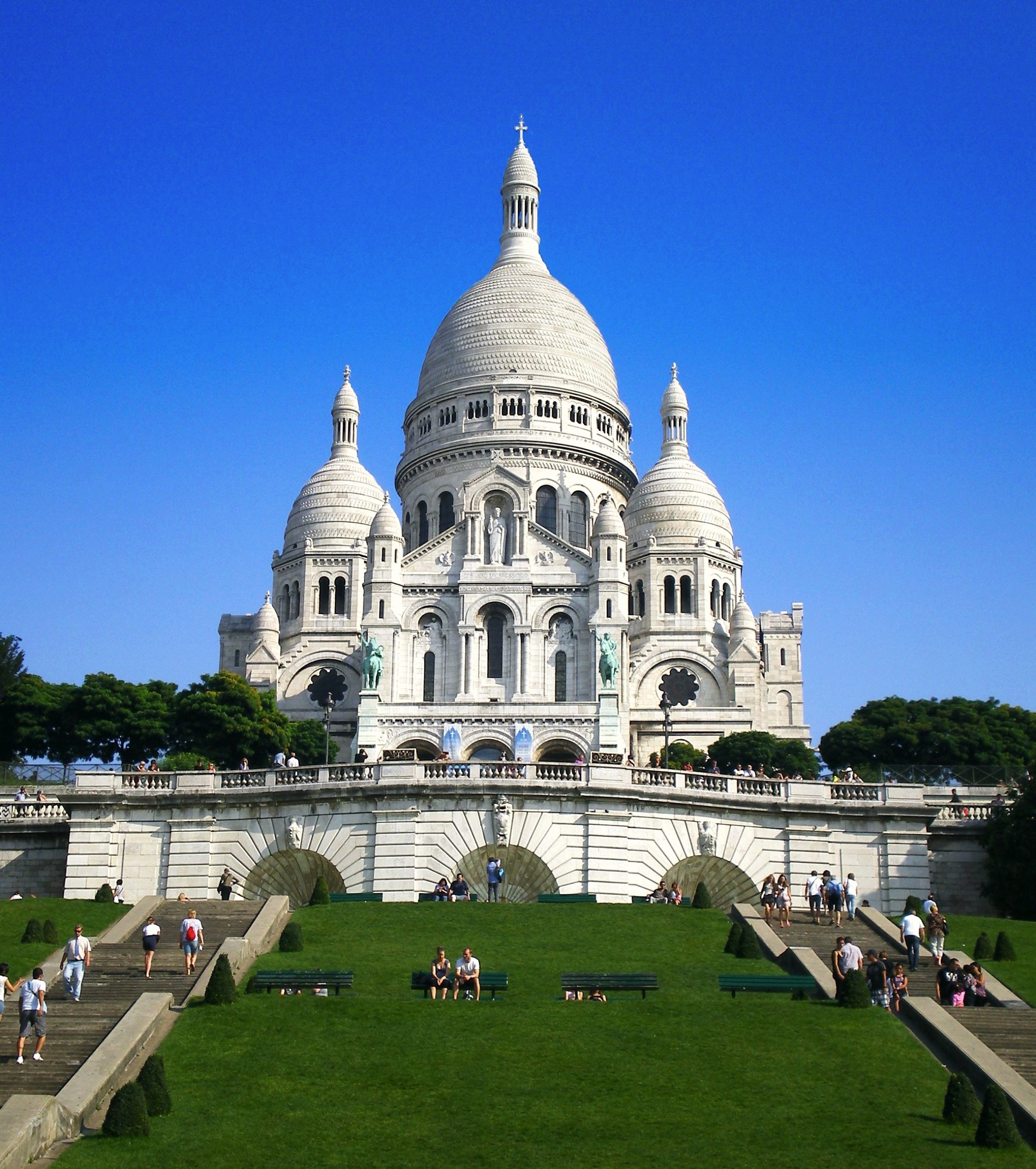Nhà thờ Sacré-Cœur trắng muốt sừng sững trên đồi Montmartre dưới nắng trời Paris