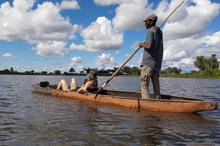 Du khách trải nghiệm thuyền độc mộc Mokoro trên sông ở Okavango Delta